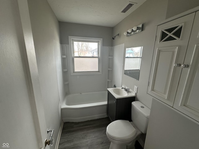 full bath with vanity, wood finished floors, visible vents, a textured ceiling, and toilet