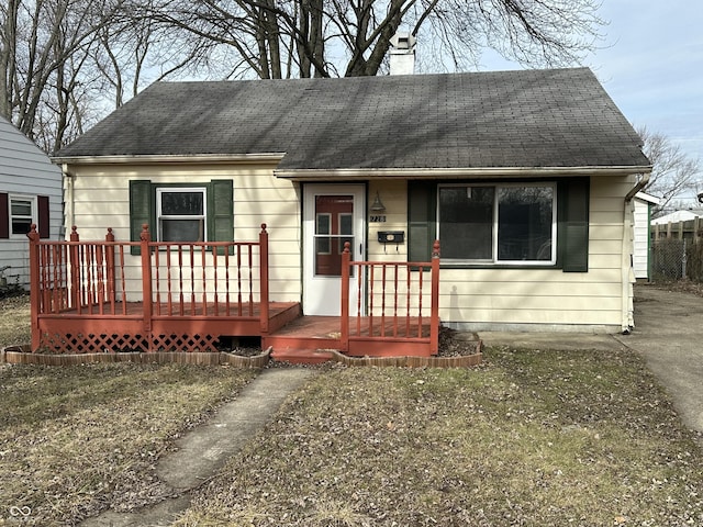 view of front of property featuring a chimney and a shingled roof