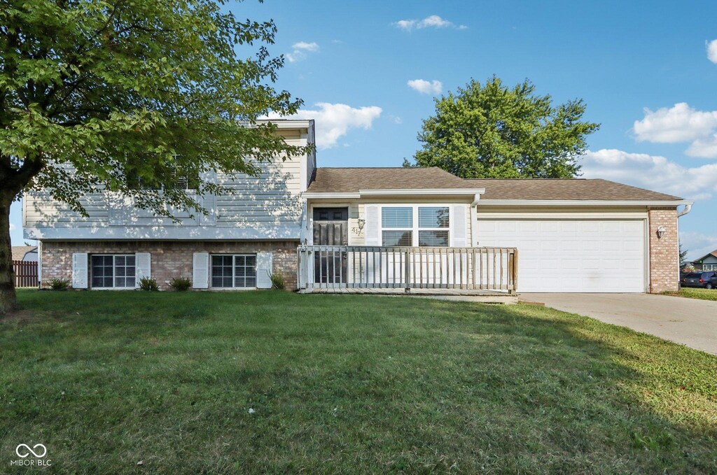 tri-level home featuring a front yard and a garage