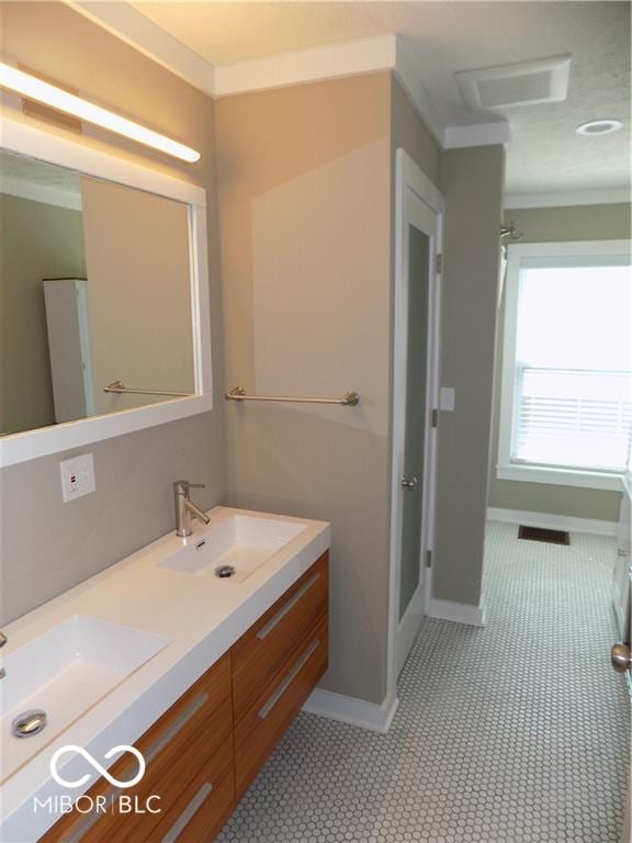 bathroom with tile patterned floors, vanity, and a shower