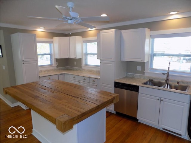 kitchen with wooden counters, stainless steel dishwasher, a center island, and white cabinets