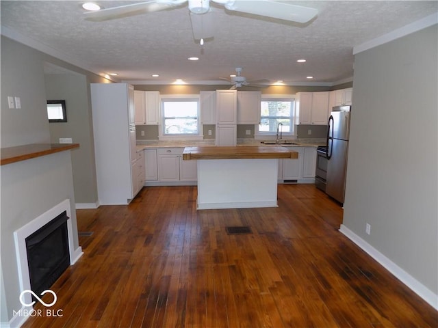 kitchen with ceiling fan, white cabinetry, dark hardwood / wood-style floors, and a healthy amount of sunlight