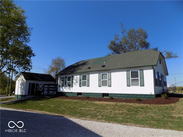 view of front of home featuring an outbuilding, a garage, and a front lawn