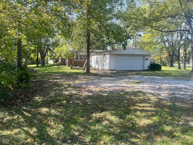 exterior space with a garage, a lawn, and an outbuilding