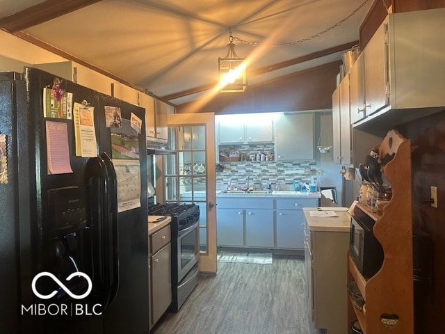 kitchen with black appliances, wood-type flooring, sink, decorative backsplash, and lofted ceiling with beams