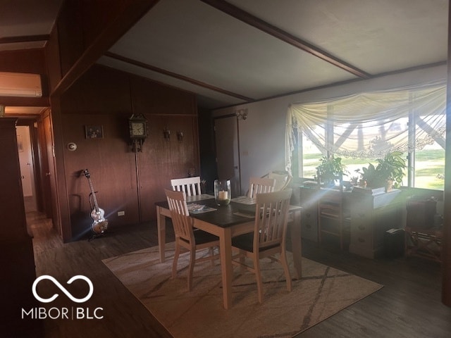 dining room with an AC wall unit and hardwood / wood-style flooring