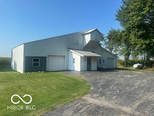 exterior space featuring an outbuilding, a front yard, and a garage