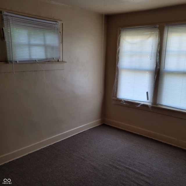 empty room with dark colored carpet