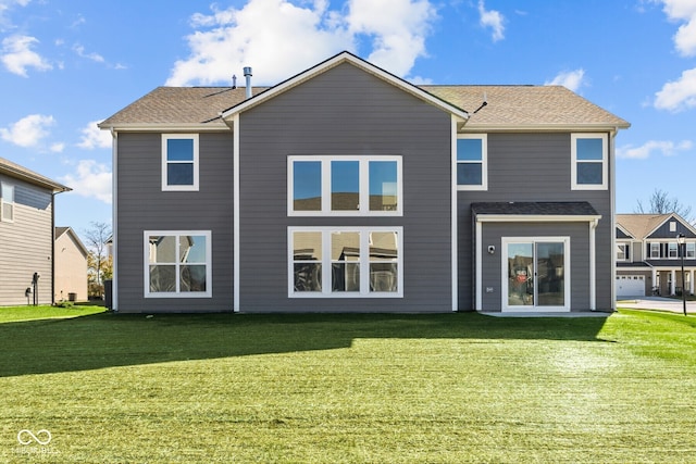 rear view of house with a garage and a lawn