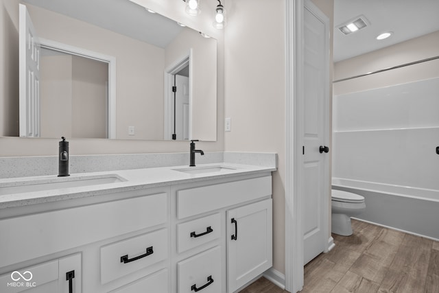 bathroom with vanity, hardwood / wood-style flooring, and toilet