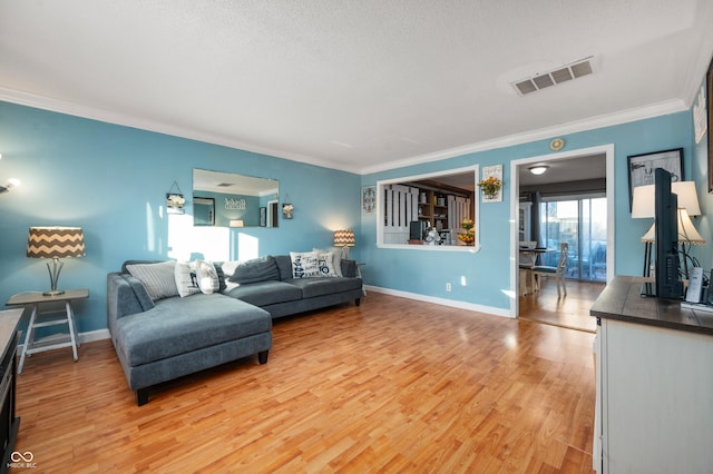 living room featuring crown molding, wood-type flooring, and a textured ceiling