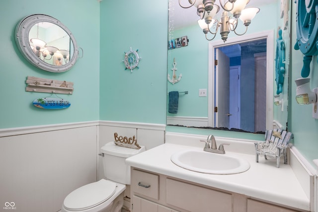 bathroom featuring a chandelier, vanity, and toilet