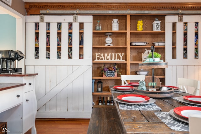 dining area with wood walls and wood-type flooring