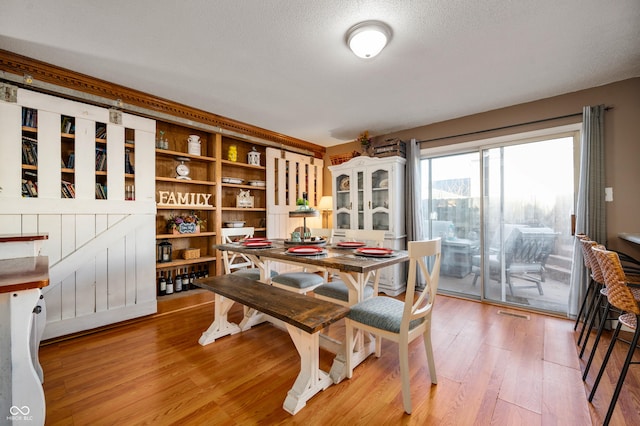 dining area with hardwood / wood-style floors and a textured ceiling