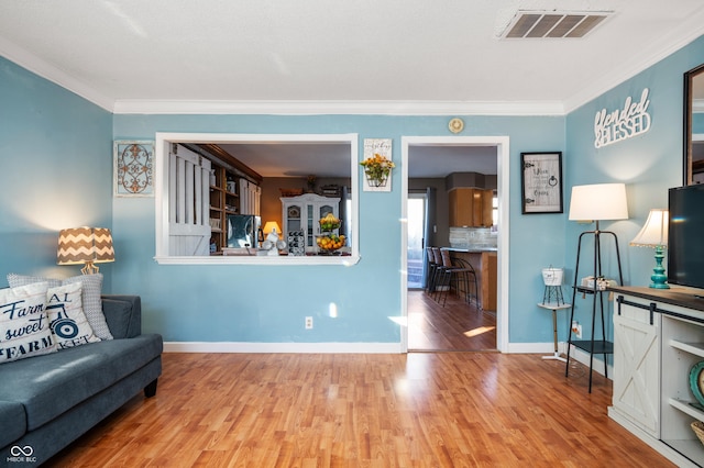 living room featuring wood-type flooring and ornamental molding