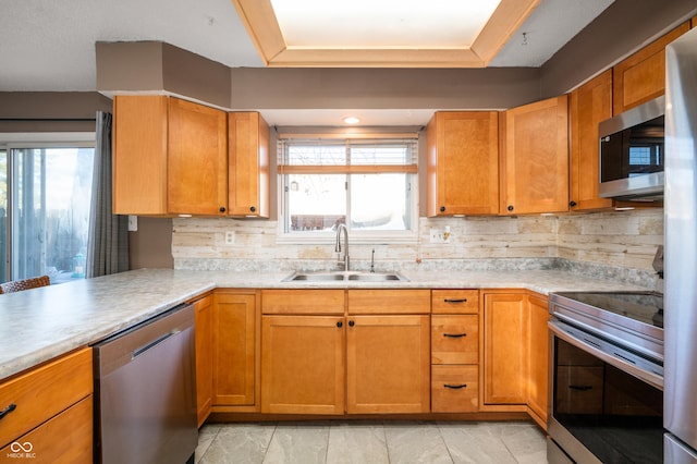 kitchen featuring decorative backsplash, sink, a healthy amount of sunlight, and appliances with stainless steel finishes