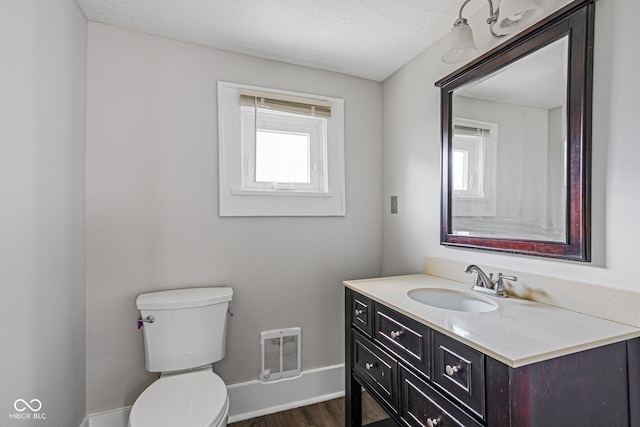 bathroom featuring a textured ceiling, vanity, toilet, and hardwood / wood-style flooring