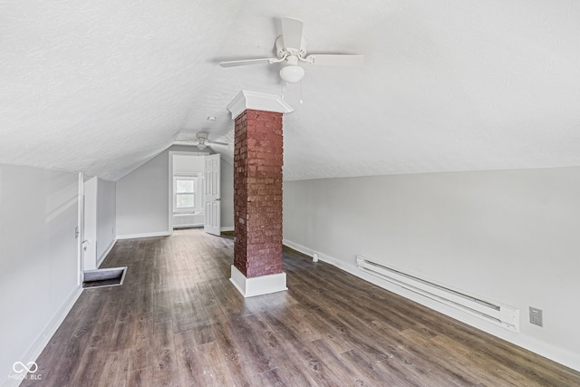 bonus room featuring dark hardwood / wood-style flooring, lofted ceiling, decorative columns, a baseboard heating unit, and ceiling fan