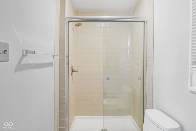 bathroom featuring walk in shower and toilet