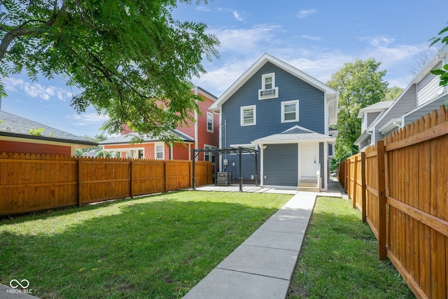 back of house with a patio area and a yard