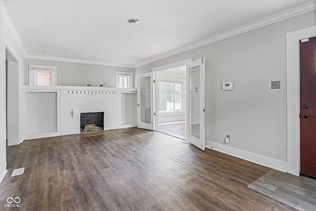 unfurnished living room featuring a textured ceiling, ornamental molding, hardwood / wood-style flooring, and a fireplace