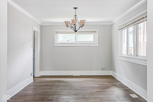 empty room featuring ornamental molding, dark hardwood / wood-style floors, and a chandelier