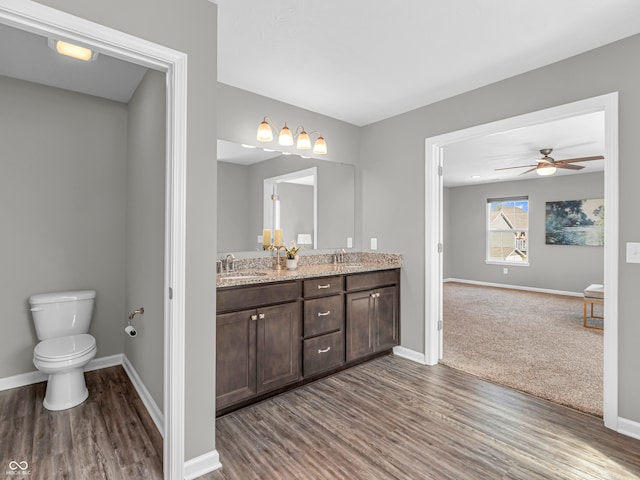 bathroom featuring hardwood / wood-style floors, vanity, toilet, and ceiling fan