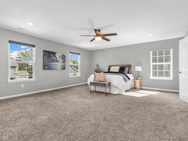 carpeted bedroom with ceiling fan and multiple windows