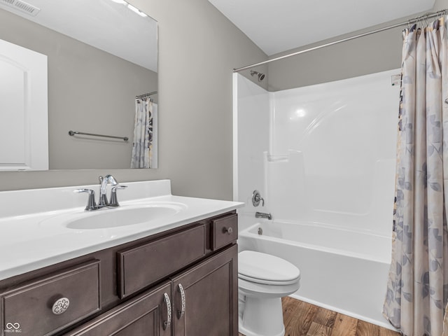 full bathroom with wood-type flooring, vanity, shower / tub combo, and toilet