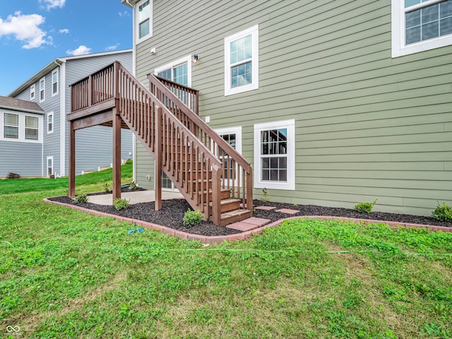 rear view of property featuring a lawn and a wooden deck