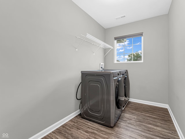 laundry area featuring dark hardwood / wood-style floors and washing machine and dryer