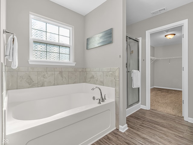 bathroom featuring independent shower and bath and wood-type flooring