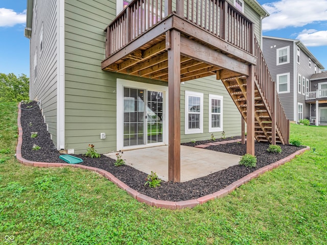 back of property featuring a yard, a wooden deck, and a patio area