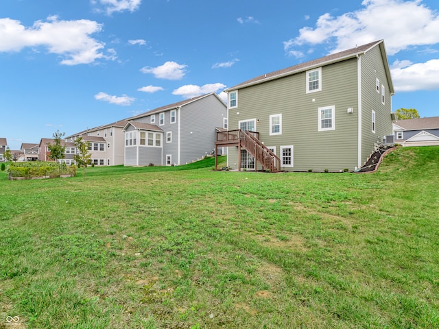 rear view of house with a deck and a yard