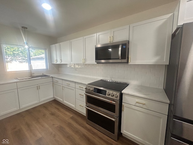 kitchen featuring backsplash, sink, dark hardwood / wood-style floors, appliances with stainless steel finishes, and white cabinets