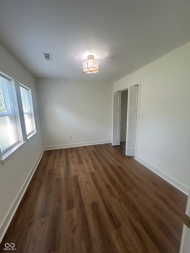 unfurnished room with dark hardwood / wood-style flooring