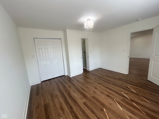 unfurnished bedroom featuring a closet and dark hardwood / wood-style floors