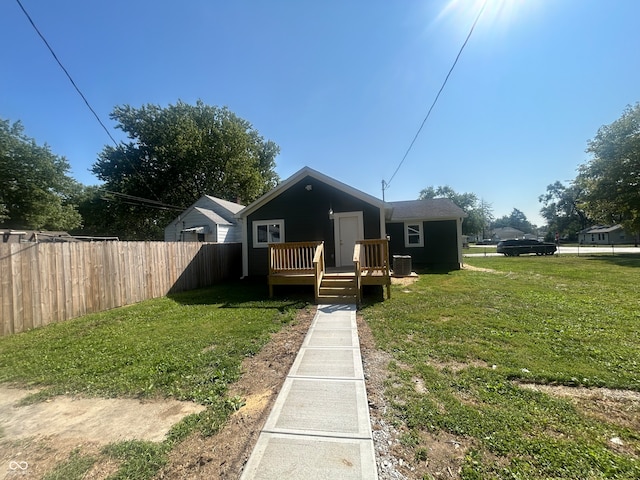 bungalow featuring a wooden deck, cooling unit, and a front yard