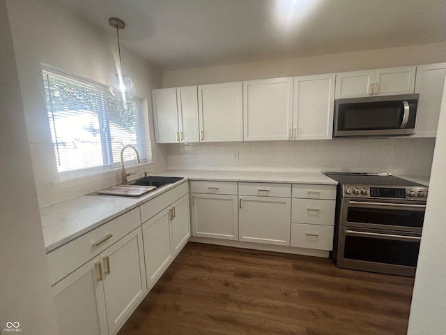 kitchen featuring tasteful backsplash, dark wood-type flooring, stainless steel appliances, sink, and hanging light fixtures