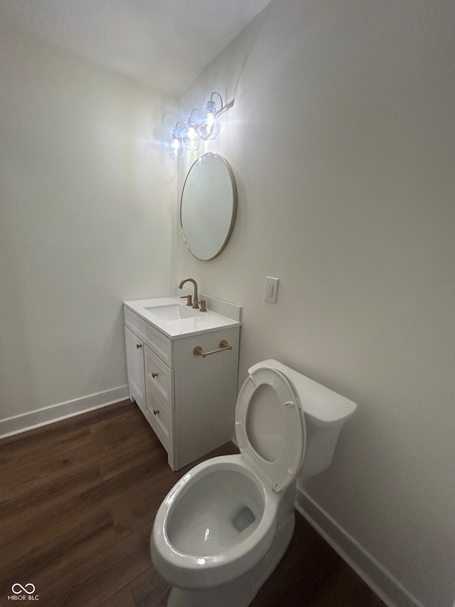 bathroom featuring toilet, hardwood / wood-style flooring, and vanity