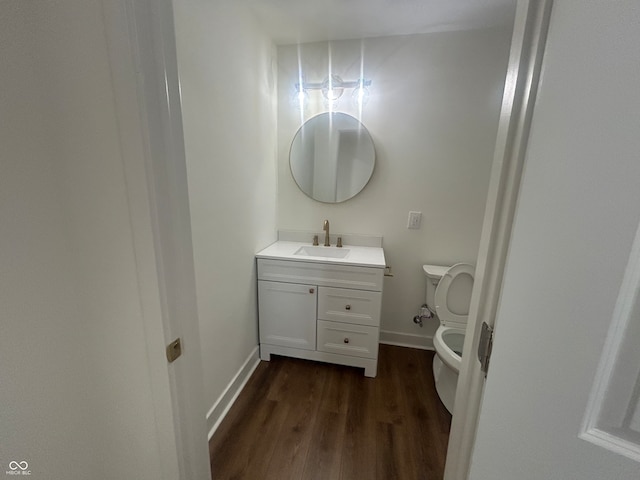 bathroom with vanity, toilet, and wood-type flooring