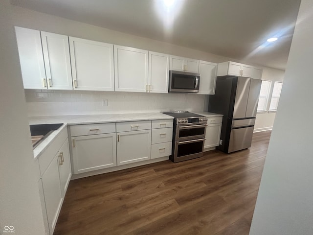 kitchen with white cabinetry, stainless steel appliances, backsplash, and dark hardwood / wood-style flooring