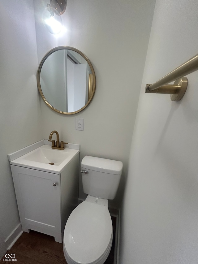 bathroom with hardwood / wood-style floors, toilet, and vanity