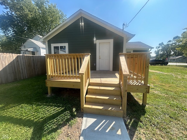 back of house featuring a lawn and a deck