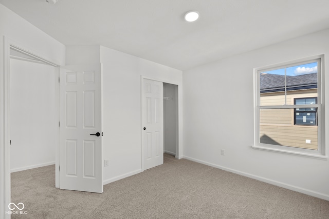 unfurnished bedroom with a closet and light carpet