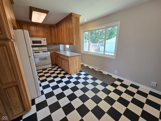 kitchen featuring white appliances and dark tile patterned floors