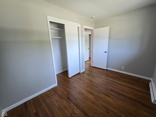 unfurnished bedroom featuring a closet and dark hardwood / wood-style flooring