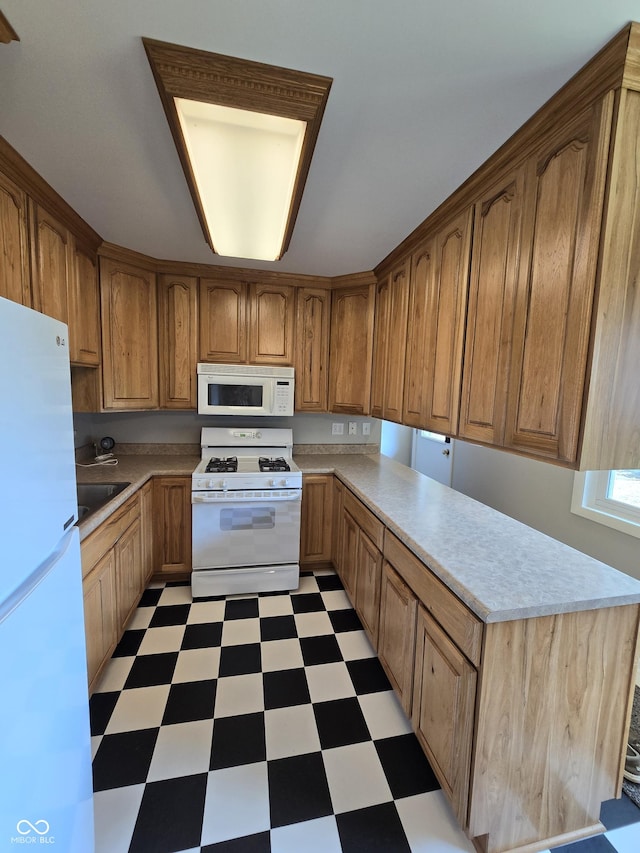 kitchen featuring brown cabinetry, white appliances, light countertops, and light floors