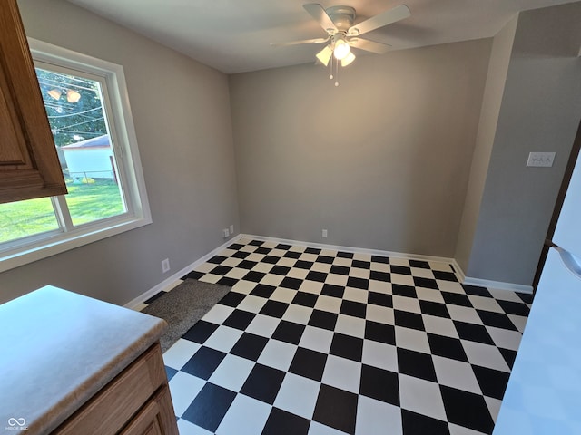 tiled spare room featuring ceiling fan