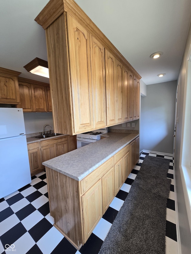 kitchen with dark floors, recessed lighting, light countertops, a sink, and white appliances